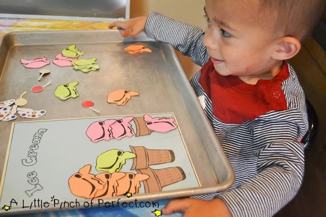 Toddler playing with ice cream scoops