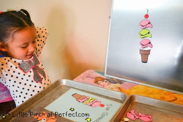 Preschooler using ice cream scoops to learn about sorting.