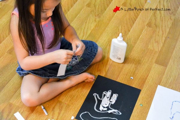 Young child creating a hand with bones craft