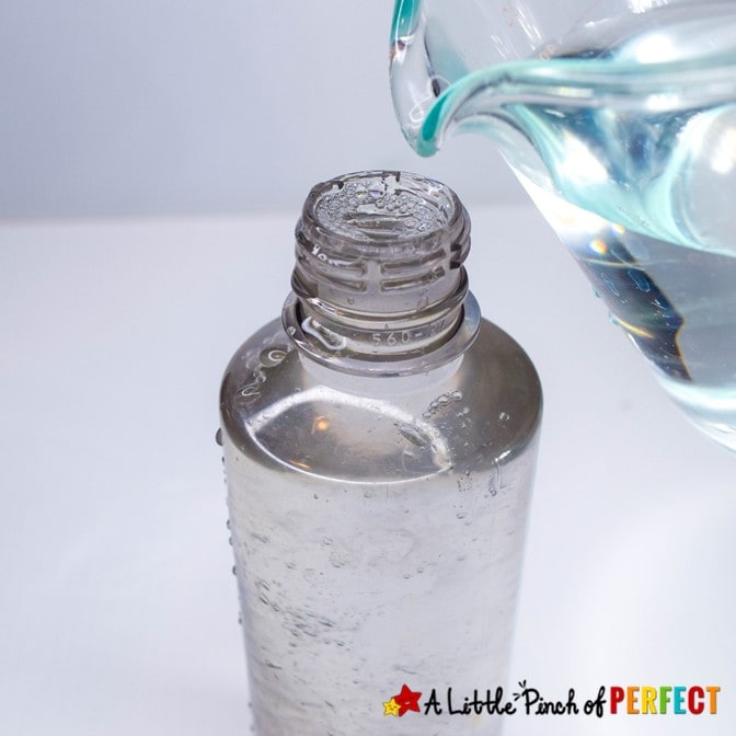 Pouring Water into Fools Gold Sensory Bottle: Make a St. Patrick’s Day Fools Gold sensory bottle that kids will love to shake and swirl the gold at a hypnotizing speed. (#stpatricksday #kidsactivity #sensorybottle #preschool #toddler)