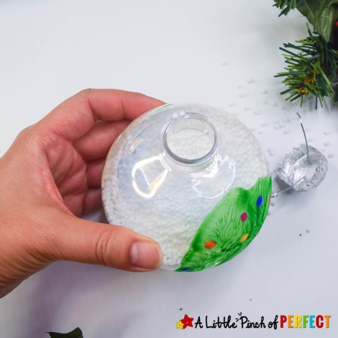 Make an adorable handprint Christmas tree ornament with our easy step by step directions and video tutorial. The ornaments turn out so cute and make great decorations, gifts, and keepsakes. #christmas #ornaments #craft #kidscrafts