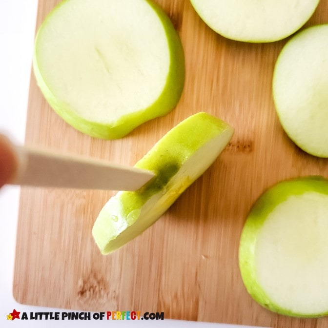 Carefully cut apple slices for caramel apples