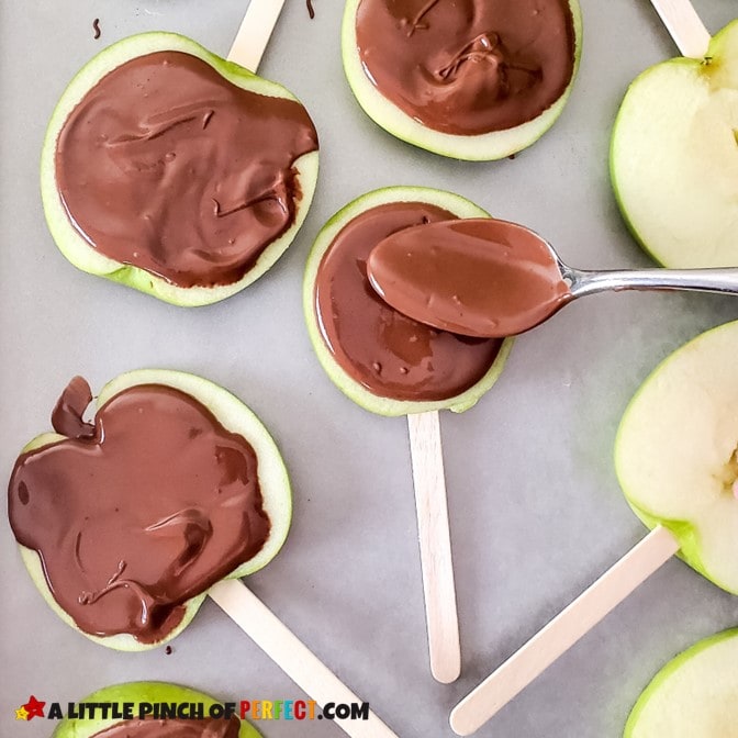 Spread melted chocolate onto apple slices to make caramel apples