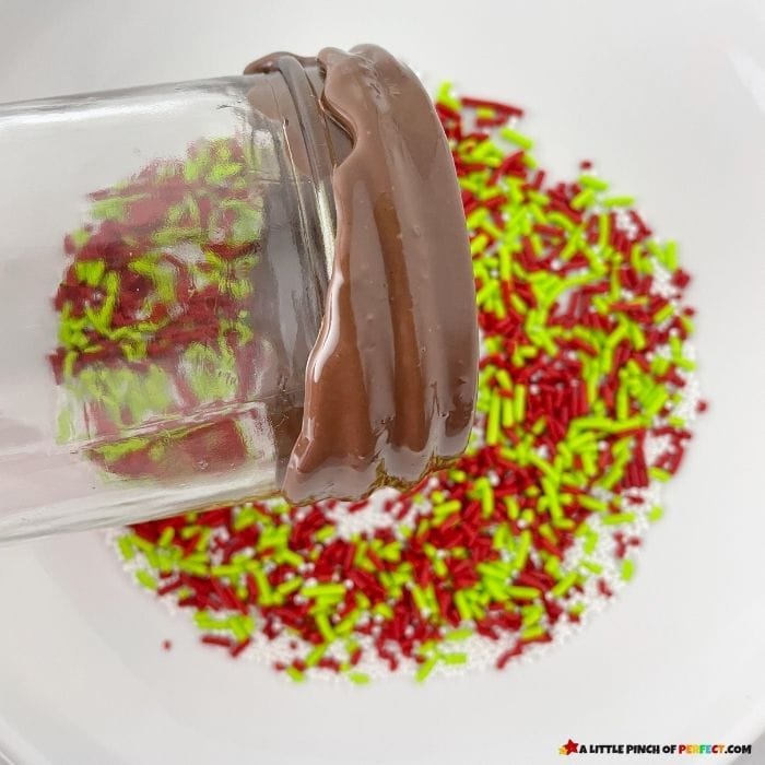 Dipping the rim of the jar in chocolate in sprinkles