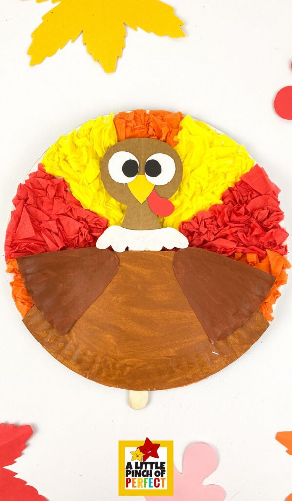 Finished paper plate turkeys displayed on classroom bulletin board as Thanksgiving decorations.