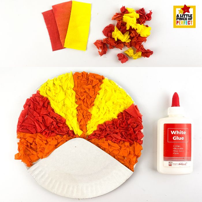 gluing colorful tissue paper onto a paper plate to create turkey feathers.