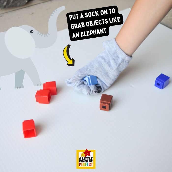 Elmer the Elephant Fine Motor Activity: Elephant Trunk Sock Game &ndash; Child wearing a sock on their hand like an elephant trunk to pick up colorful unifix cubes in a fun fine motor activity inspired by Elmer the Elephant.