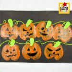 Apple stamped pumpkin patch Halloween art project for kids — the perfect Halloween art project for kids that ends with the most adorable jack-o'-lantern patch you've ever seen! The finished artwork shows every pumpkin decorated with its own unique spooky or happy black marker face, making this apple stamp craft a must-save for your fall and Halloween activity ideas.